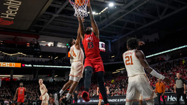 Cincinnati Bearcats forward Jamille Reynolds (13) dunks over Texas Longhorns guard Tyrese Hunter (4) in the first half of the NCAA Big 12 basketball game between the Cincinnati Bearcats and the Texas Longhorns at Fifth Third Arena in Cincinnati on Tuesday, Jan. 9, 2024.